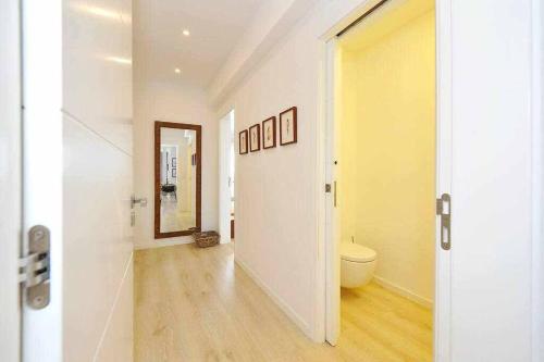 a hallway with a toilet and a mirror at Prestige Sunset Carcavelos Beach - Checkinhome in Carcavelos