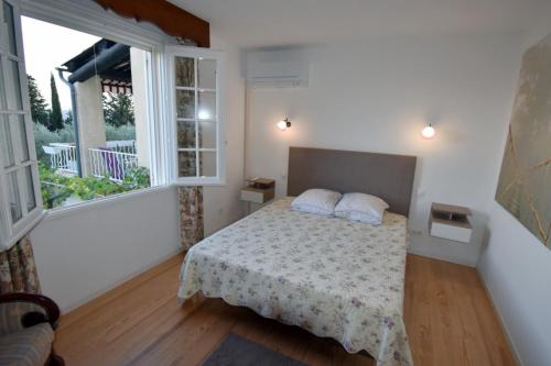 a bedroom with a bed and a large window at Chambre d'hôtes et Spa en Luberon in Volx