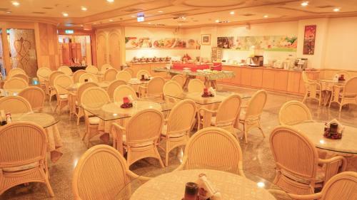 une salle avec des tables et des chaises et une cafétéria dans l'établissement Hwa Du Hotel, à Tainan