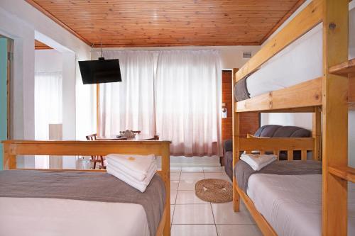 a bedroom with two bunk beds and a television at 25 Jacaranda Lodge & Backpackers in Pinetown