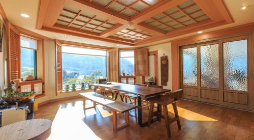 comedor con mesa, sillas y ventanas en ChungDam, en Pyeongchang