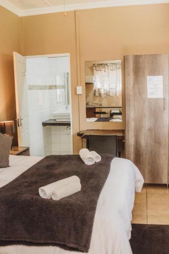 a hotel room with two towels on a bed at Casa Leitao Lodge in Phalaborwa