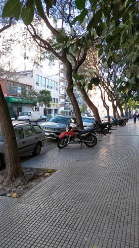 una motocicleta estacionada en una acera junto a los árboles en Petit Apartment en Avenida Belgrano en Buenos Aires