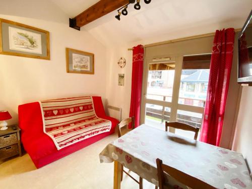 - un salon avec un canapé rouge et une table dans l'établissement Appartement Morillon 1100, 3 pièces, 5 personnes - FR-1-412-19, à Morillon