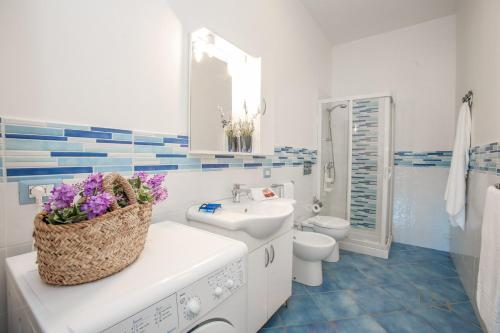 uma casa de banho branca com um lavatório e um WC em Casa Tirreno in Villa con piscina a 2 passi dal mare em Pozzallo
