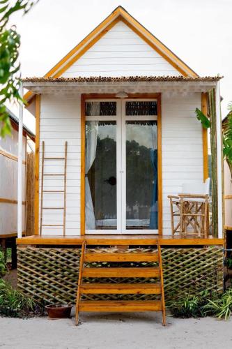 een tiny house met een raam en een ladder bij Vietnam Surf Camp in Ấp Mỹ Hải