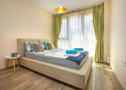 a bedroom with a large bed with a window at Brand new Central apartment, 10 minutes to Center in Plovdiv