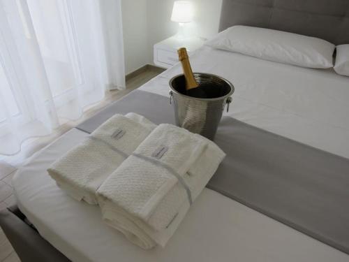 einen weißen Tisch mit Handtüchern auf dem Bett in der Unterkunft Bellini Luxor - ApartHotel in Molfetta