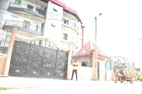une femme marchant dans une rue devant un bâtiment dans l'établissement Stylish 2-bedroom apartment, 24 hrs security, wifi, à Bonamakolo