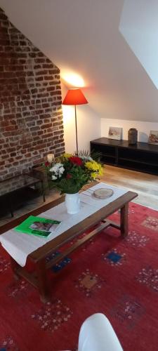 a living room with a table and a brick wall at Studio32 in Honfleur