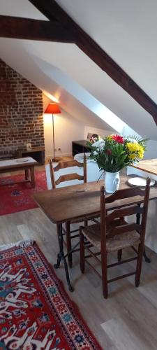 Una sala de estar con una mesa de madera con flores. en Studio32, en Honfleur