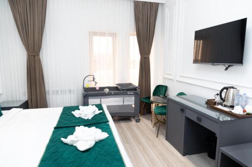 a hotel room with a bed and a desk with towels at Marokand Spa Hotel in Samarkand