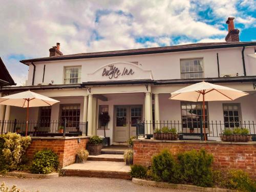 ウィンチェスターにあるThe Bugle Inn Twyfordの傘が前に置かれた白い建物