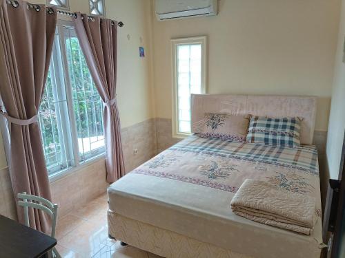 a bed in a room with windows and a bed sidx sidx sidx at Ndalem Gorongan Guesthouse in Yogyakarta