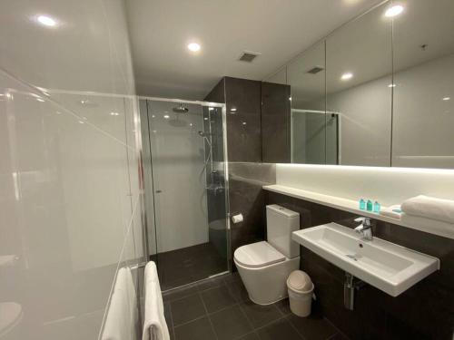 a bathroom with a shower and a toilet and a sink at New! Great Value - Skytower center of CBD in Brisbane