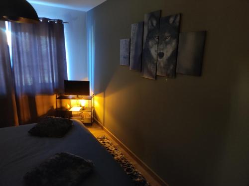 a bedroom with a bed and two paintings on the wall at Gîte La Renéade in Foyr