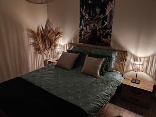 a bedroom with a bed and two night stands with lamps at Gîte La Renéade in Foyr