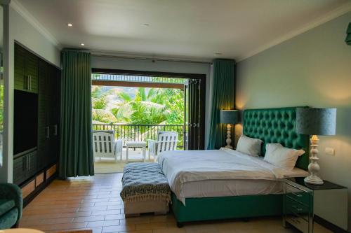 a bedroom with a large bed and a balcony at Maison La Plage by Simply-Seychelles in Eden Island