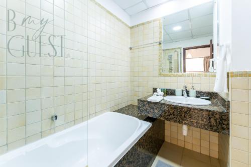 a bathroom with a tub and a sink at Sadaf 4 3BR+Maid's Room in Dubai