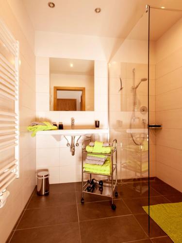 a bathroom with a shower and a sink and a cart at LoriVita Residenz Saalbach in Saalbach-Hinterglemm
