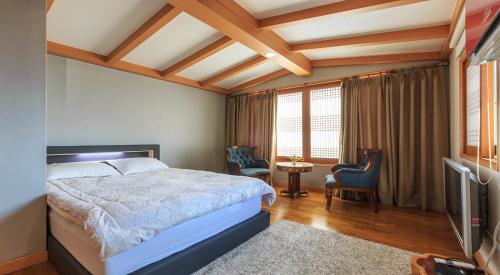 1 dormitorio con 1 cama y TV en una habitación en ChungDam, en Pyeongchang