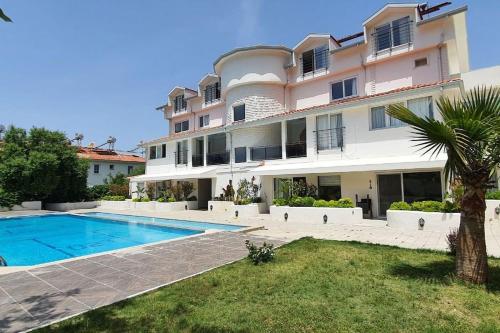 a large apartment building with a swimming pool in front of it at Harika bir yer in Oludeniz
