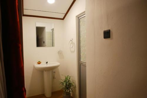 a bathroom with a sink and a mirror at Coastal House in Mirissa