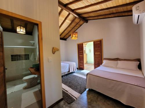 1 dormitorio con 2 camas y baño con ducha en Bons Ventos Camping e Glamping, en Barra Grande