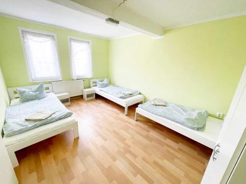 Zimmer mit 2 Betten und 2 Fenstern in der Unterkunft Fully Equipped Flat with *3BR* + *1LR* in Apolda