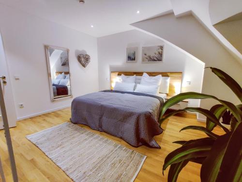a bedroom with a bed and a potted plant at Hejm Apart - Design Maisonette-Ferienwohnung "Zugspitze" in Mering