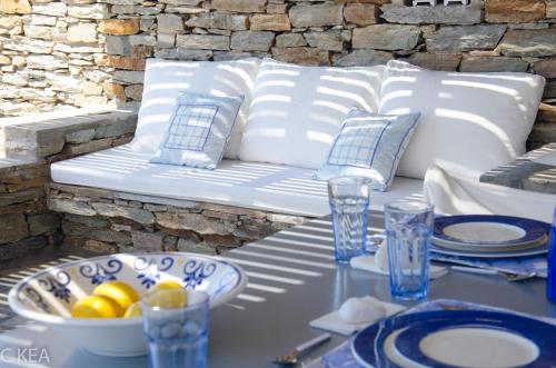 a white couch sitting on a table with a bowl of fruit at Fantastic waterfront home in Koundouros, Kea in Ioulida