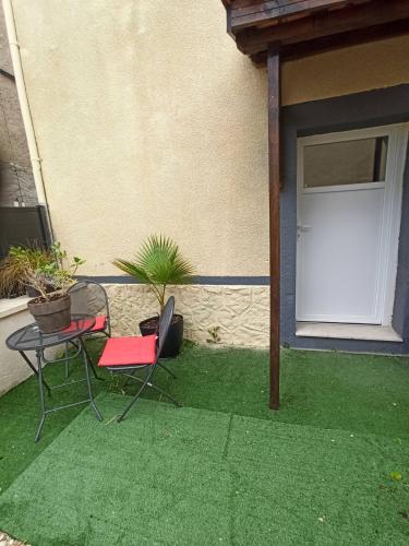 a patio with a table and a chair and a door at Chambres d'hôte in Thenon