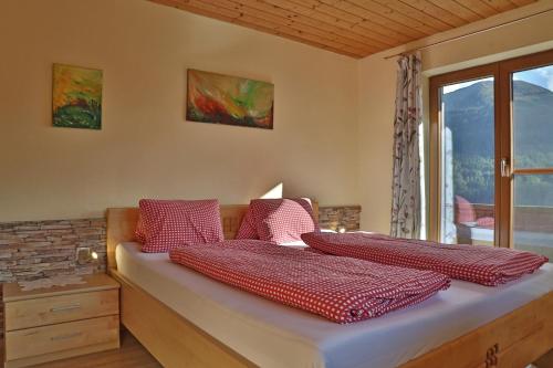 Un dormitorio con una cama con almohadas rojas. en Himmenhof en Tux