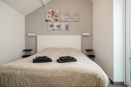 een slaapkamer met een bed met twee zwarte handdoeken erop bij Hello Zeeland - Vakantiehuis Wijngaardstraat 12 in Domburg