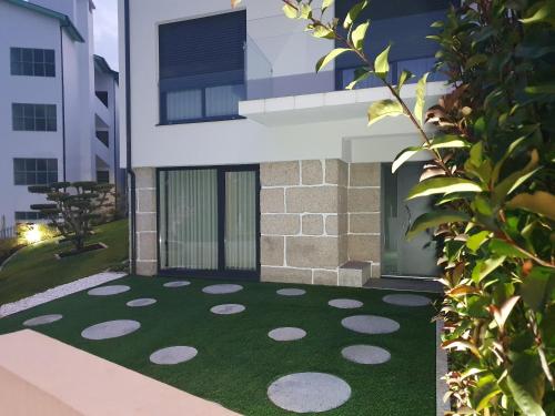 a house with a green floor with a building at PIMENTA FOUR HOUSE in Amarante