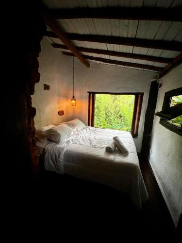Un dormitorio con una cama con un par de zapatos encima. en Chalezinho Na Mata Cipó Luxo - Inesquecível (privativo na mata e no centro da serra), en Santana do Riacho