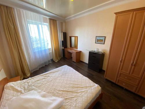 een slaapkamer met een bed en een groot raam bij Gagarina Naberegnaya in Dnipro