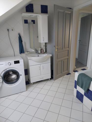 een badkamer met een wastafel en een wasmachine bij City Corner Thermal in Mosonmagyaróvár