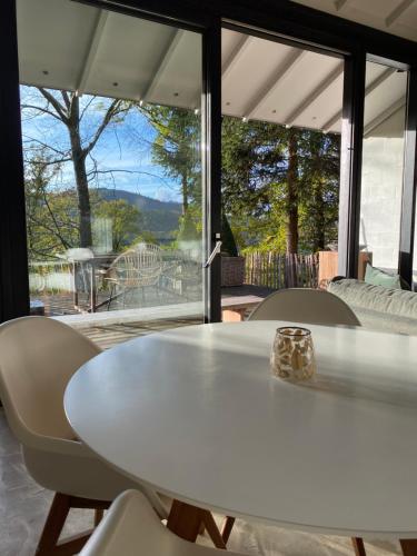 tavolo e sedie bianchi in una stanza con una grande finestra di Le petit ours de Coo a Stavelot