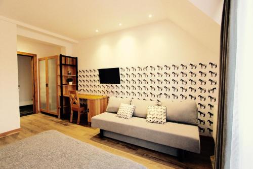 a living room with a couch and a wall with birds on it at KOŃSKA GÓRKA Agroturystyka in Rabka