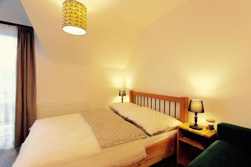 a bedroom with a bed and a lamp and a window at KOŃSKA GÓRKA Agroturystyka in Rabka