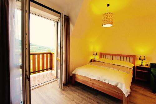 a bedroom with a bed and a large window at KOŃSKA GÓRKA Agroturystyka in Rabka