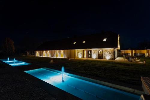 une maison éclairée la nuit avec une piscine dans l'établissement Resort Village Majer, à Gradac