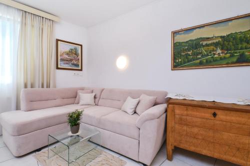 a living room with a couch and a painting on the wall at Apartments Antares in Mali Lošinj