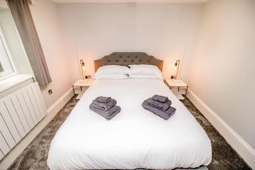- une chambre avec un lit blanc et des serviettes dans l'établissement Spacious 2 bed city centre apartment with parking, à Norwich