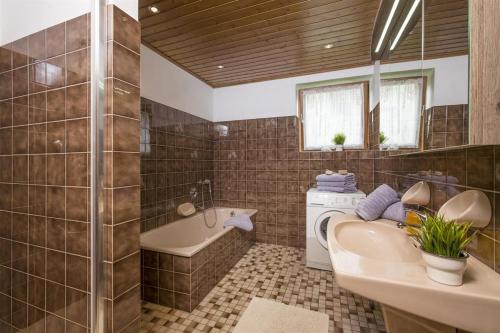 瑟爾的住宿－Ferienhaus Lanzinger，带浴缸水槽和洗衣机的浴室