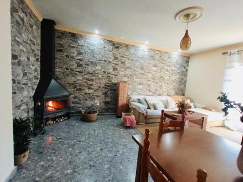 - un salon avec un mur en pierre et une cheminée dans l'établissement Apartamento con vistas a la Sierra de El Torcal, à Villanueva de la Concepción