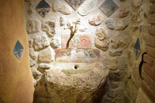 a stone bathroom with a statue on the wall at Il Castello in Petralia Sottana