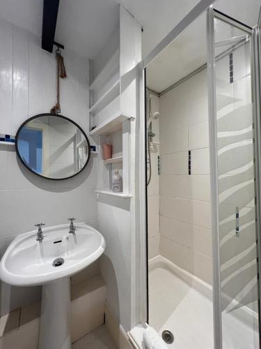 a white bathroom with a sink and a shower at Halwell House - A Spacious Quiet Apartment in Kingsbridge