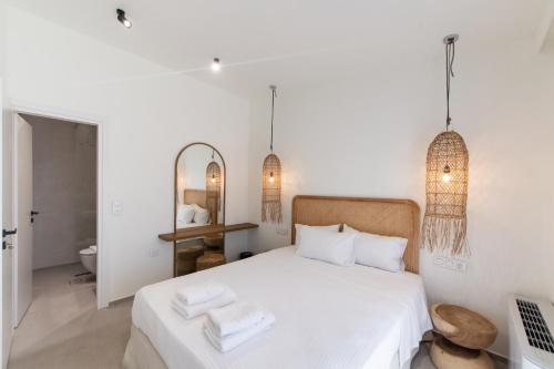 een slaapkamer met een wit bed en 2 handdoeken bij Pnoe - Feel at Home in Lefkada